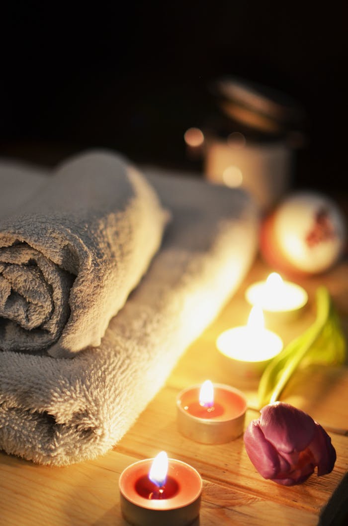 about-01 Relaxing spa atmosphere with candles, towels, and a tulip, perfect for wellness and self-care.